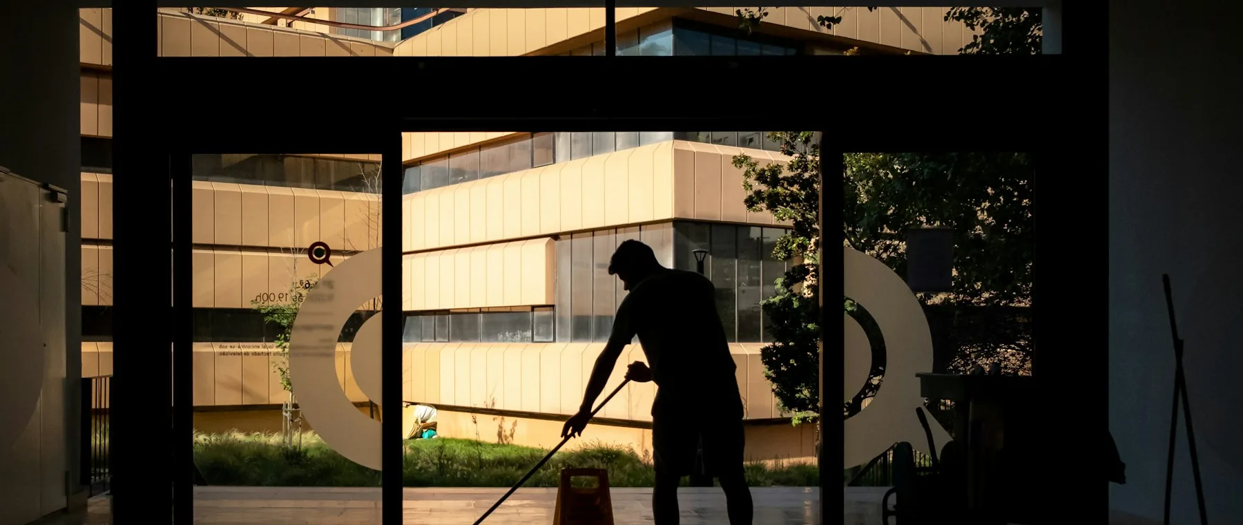 A cleaner working on a large commercial floor with industrial equipment.
