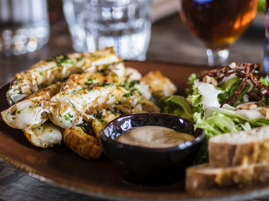 An assortment of open sandwiches and small plates on a wooden board.