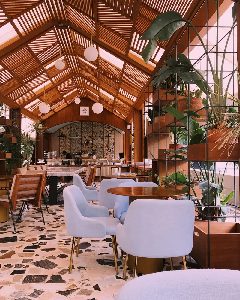 A venue interior set with rented tables and chairs under a timber roof.