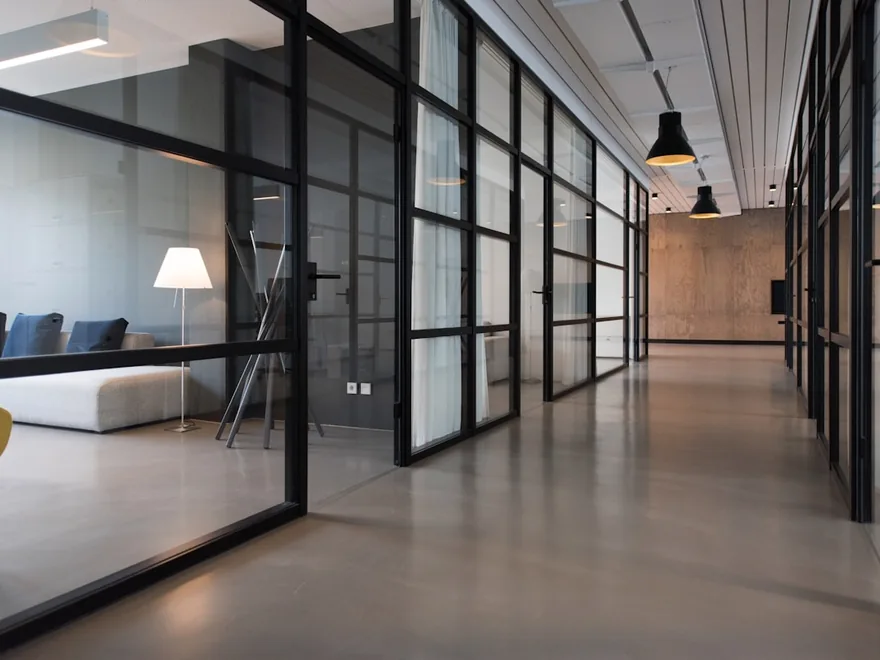 A clean modern office with polished floors and glass partitions.