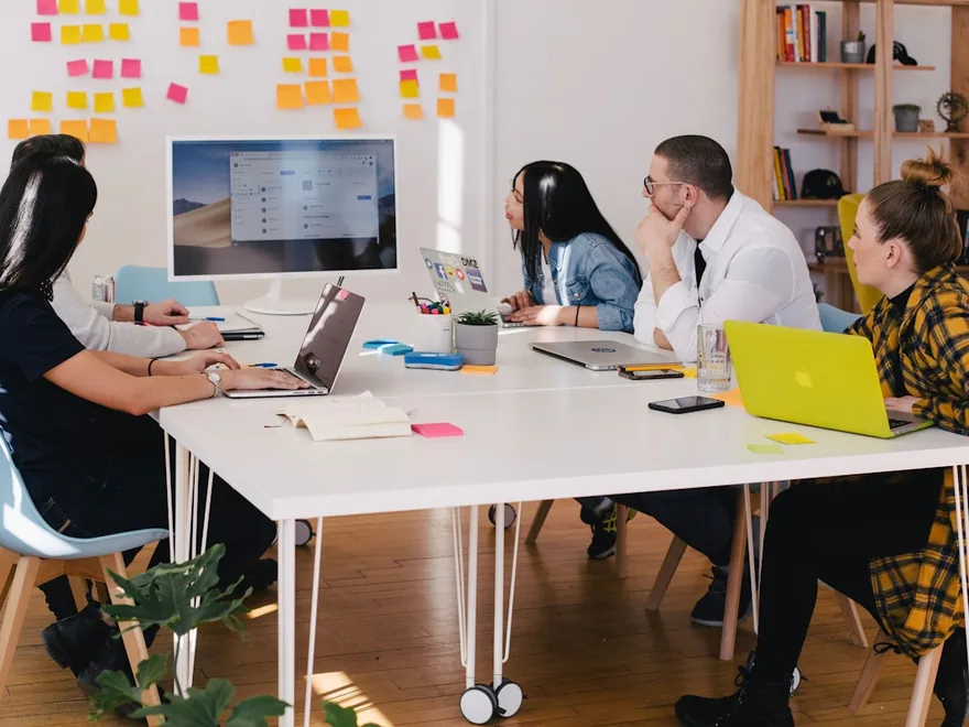 A planning session around a table with notes and laptops.