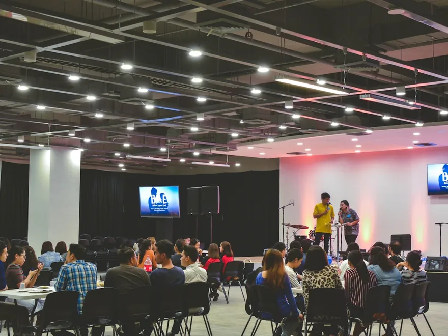 Delegates seated at round tables during a corporate conference session.
