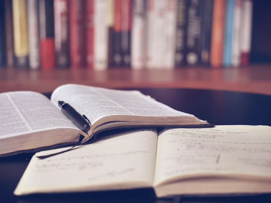 An open book resting on a table in warm light.