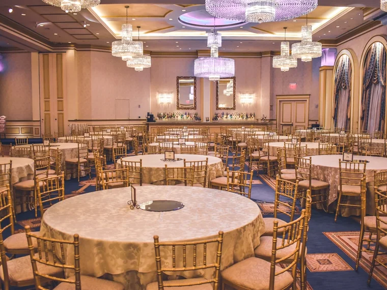 A ballroom laid out with rented round banquet tables and chairs.