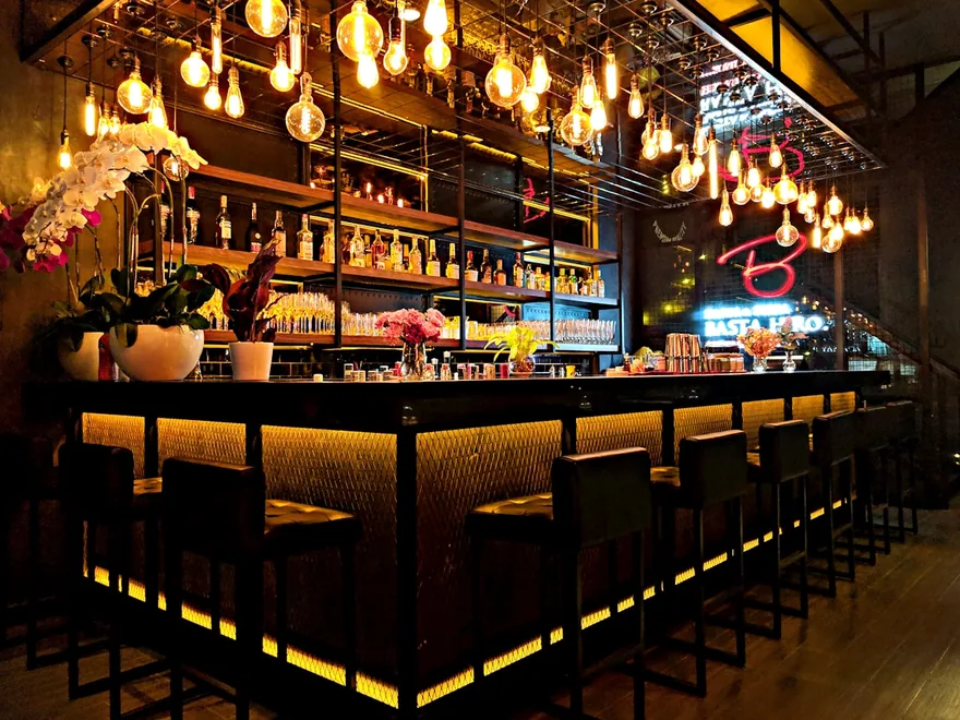 An illuminated bar counter with pendant lighting.